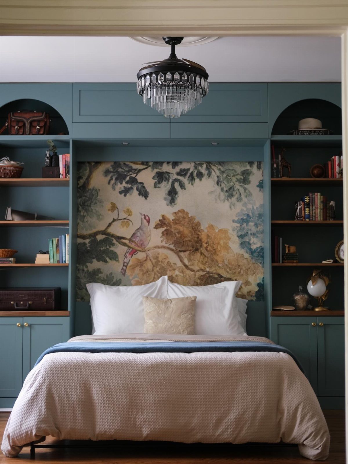 15 Apartment Decor Inspiration Ideas for Small Living Spaces 11 Bed integrated into a teal built-in wall unit with bookshelves and a mural.