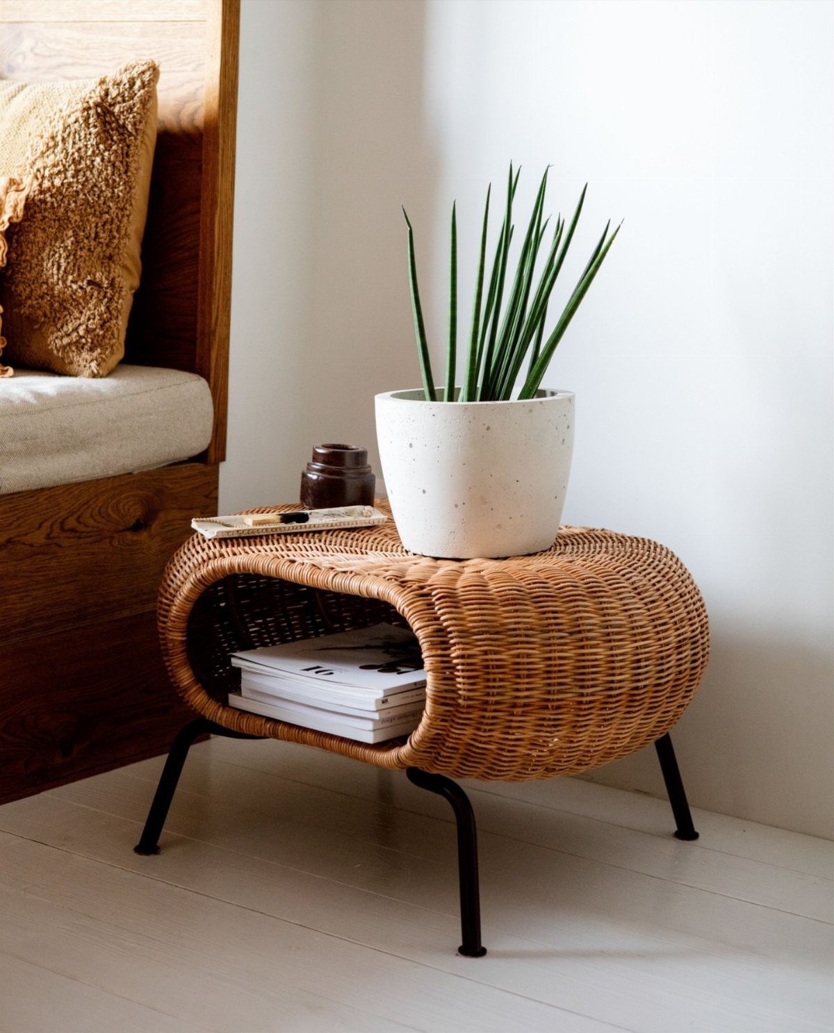 15 Apartment Decor Inspiration Ideas for Small Living Spaces 9 Woven wicker side table with a potted plant and magazines stored inside.