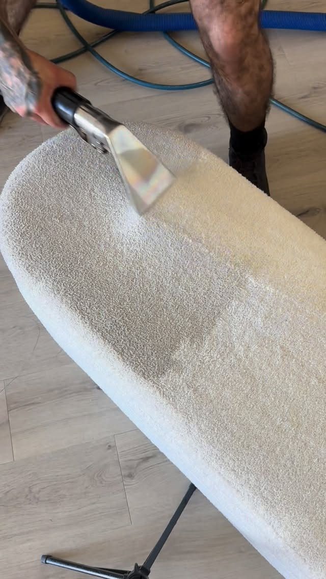 Apartment Deep Clean: 14 Areas to Scrub, Dust, and Vacuum 4 Steam cleaning tool refreshing a light grey upholstered chair on wood flooring