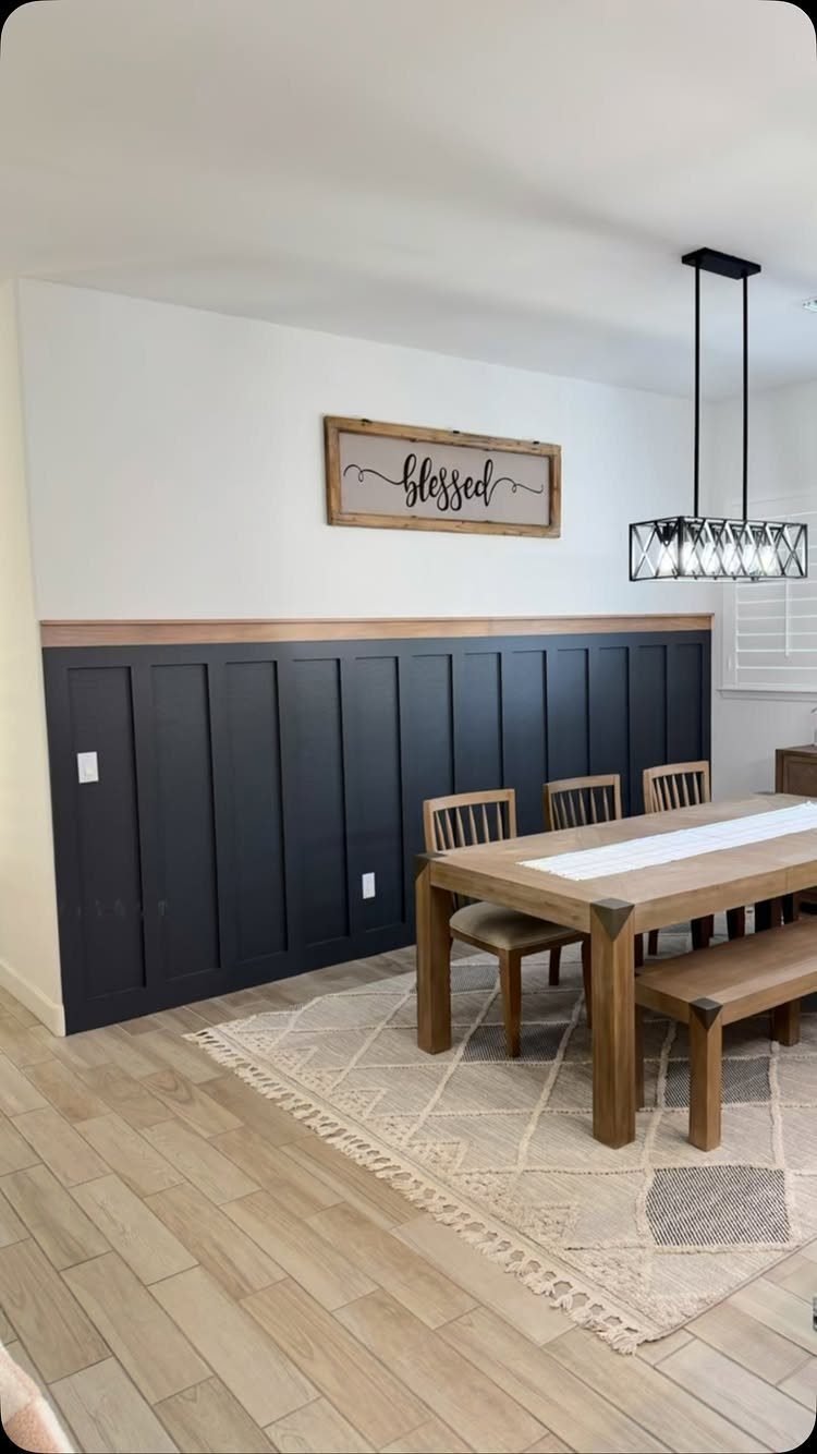 Board and Batten: 8 Styles That Update the Classic Wall Treatment 7 Dark navy board and batten wainscoting in a dining room with a wooden table.