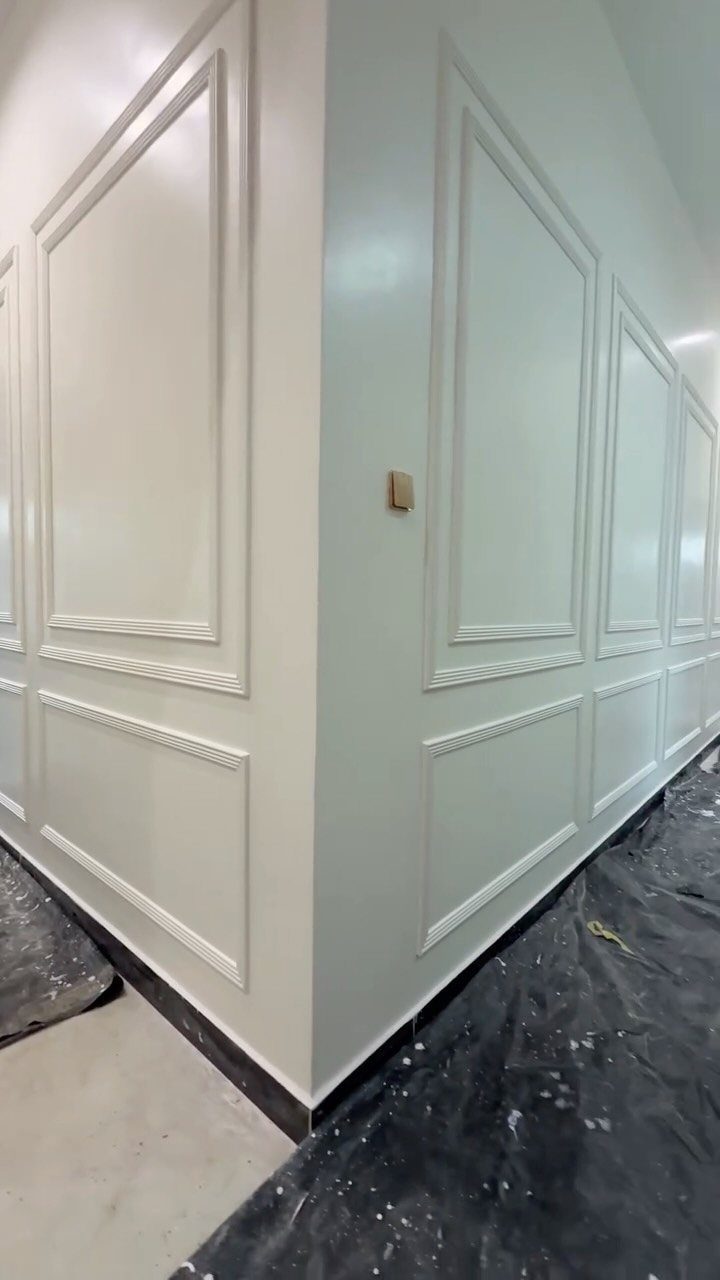 White walls featuring decorative rectangular box moulding patterns in a corner of a room.
