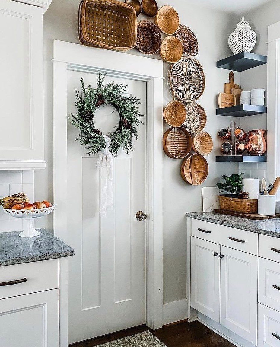 A collection of woven baskets arranged decoratively on a white wall above a door.