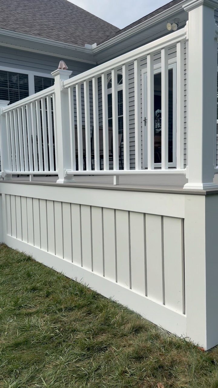 White board-and-batten skirting underpinning a deck with a matching white railing.