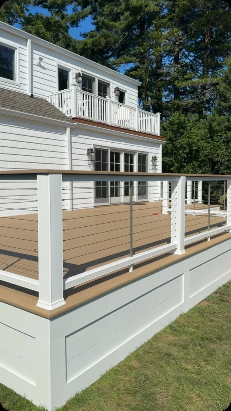 Wooden deck with white railings and white skirting panels covering the underpinning area.