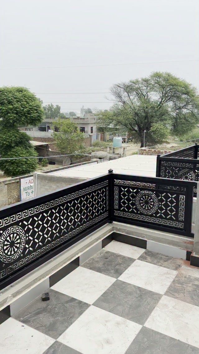 Fence Grill Design Modern: 28 Ideas from Steel to Aluminum 22 Black metal fence grill with geometric patterns on a checkered tile rooftop balcony.