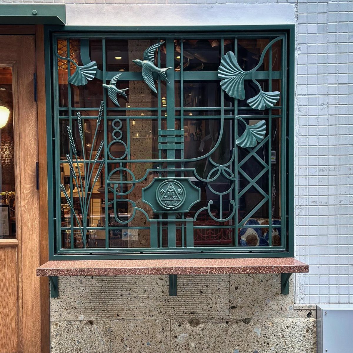 Fence Grill Design Modern: 28 Ideas from Steel to Aluminum 5 Decorative green metal window grill with bird and leaf motifs on a white wall.