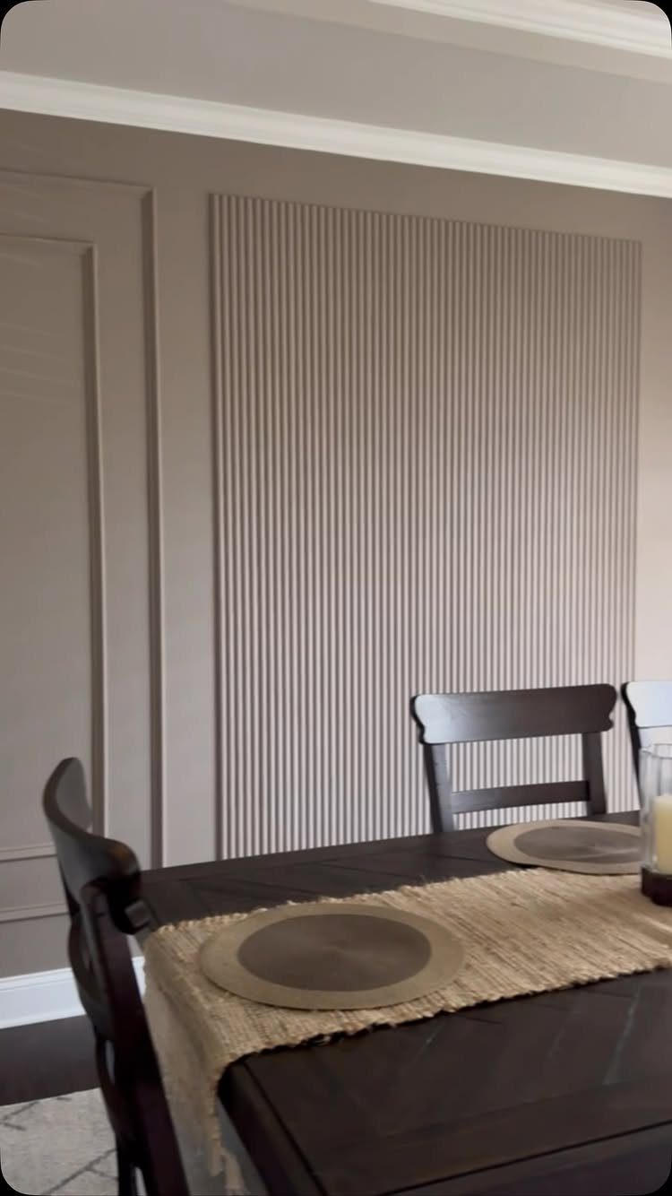 Vertical slat wall paneling and rectangular wall molding in a dining room setting.