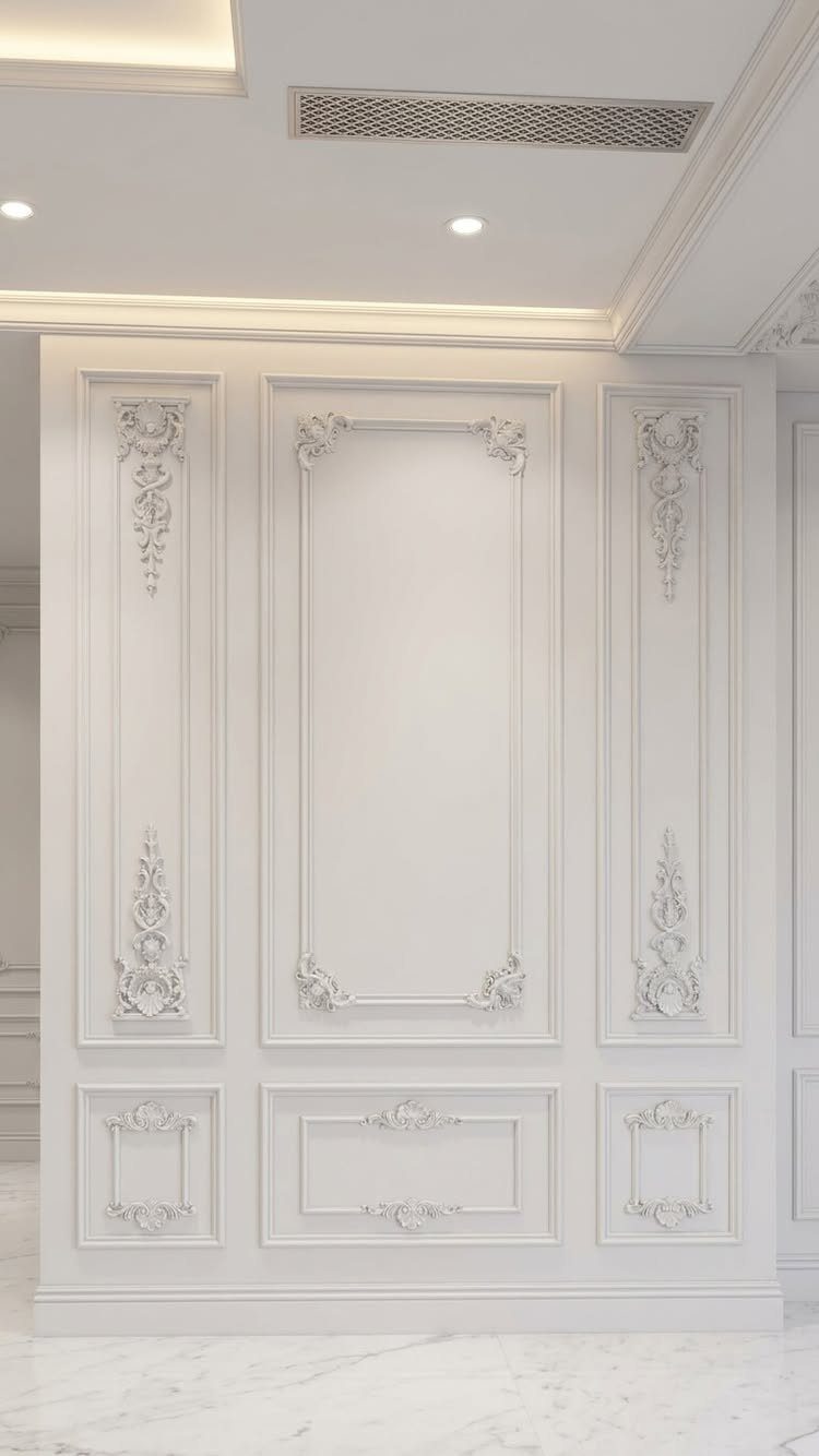 White decorative wall moulding with ornate floral carvings and rectangular panel designs on a wall.