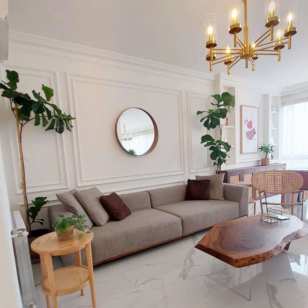 White decorative wall moulding panels in a bright, modern living room with a grey sofa.