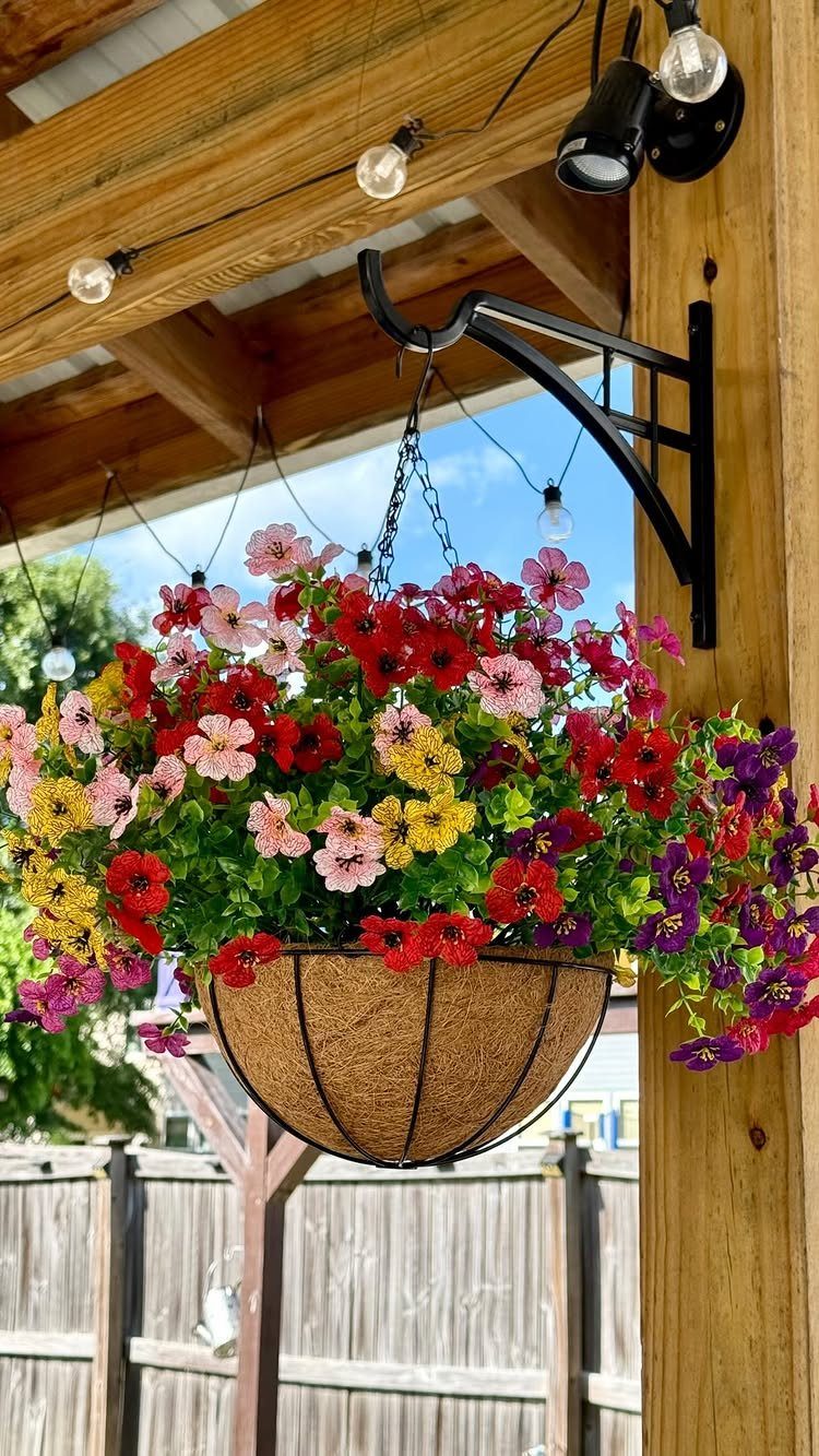 20 Garden Ideas for Small Spaces, From Vertical to Fire Pits 5 Colorful petunias in a coconut-fiber hanging basket suspended from a wooden pergola beam.