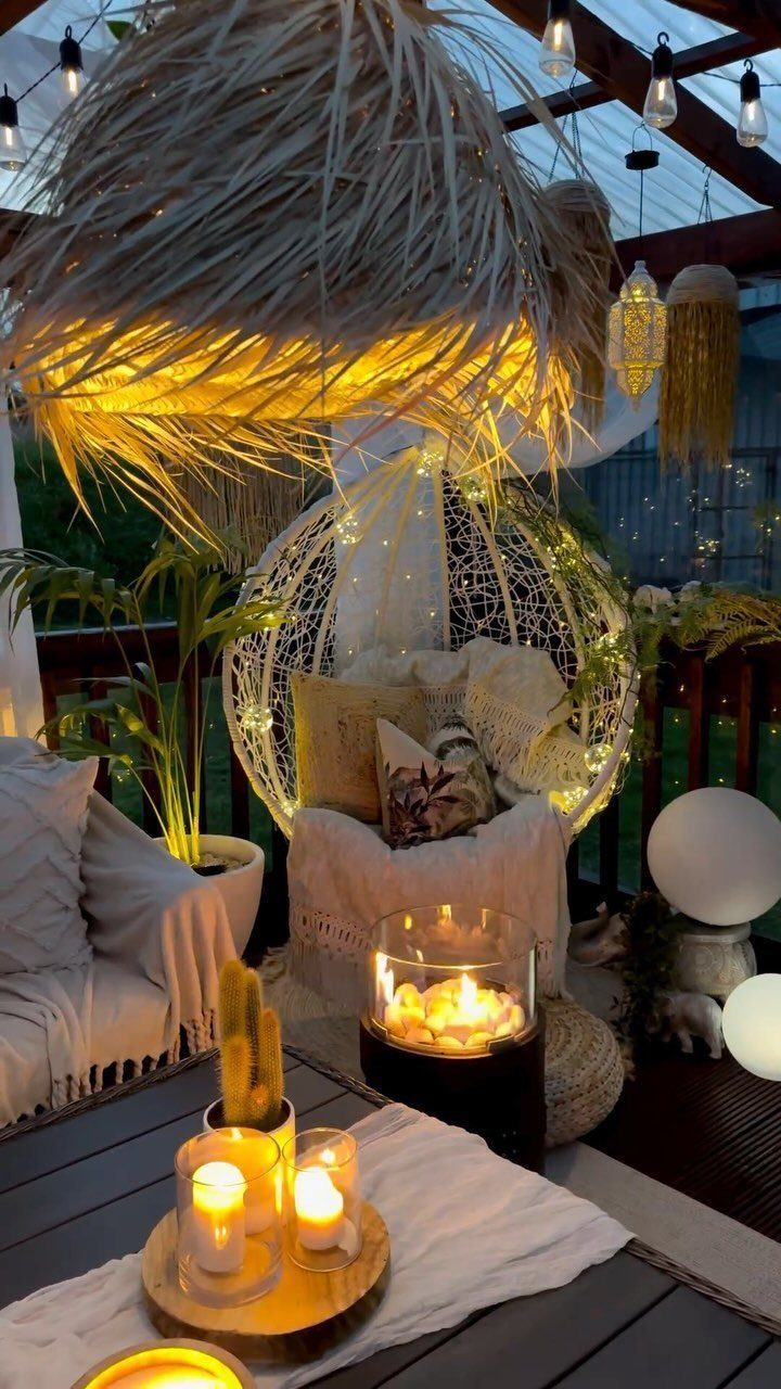 20 Garden Ideas for Small Spaces, From Vertical to Fire Pits 7 Cozy outdoor patio with string lights, glowing orb lamps, and candles at dusk.