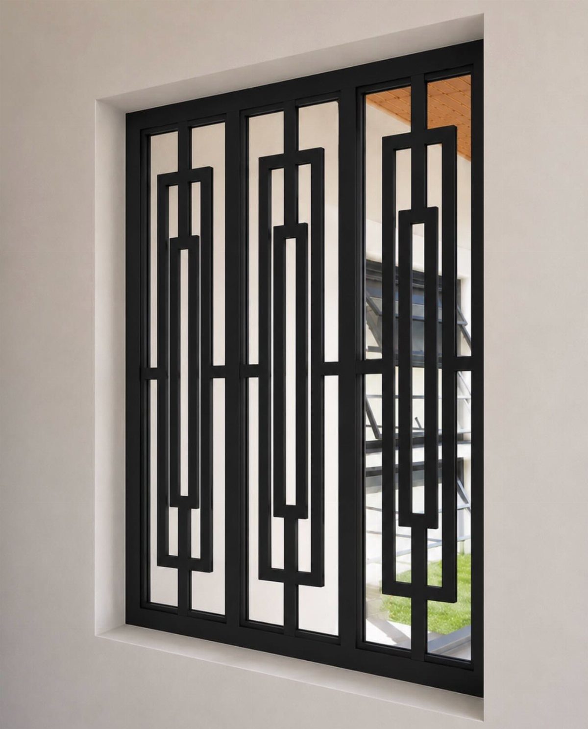 Black metal window grill with geometric rectangular patterns set in a white wall.
