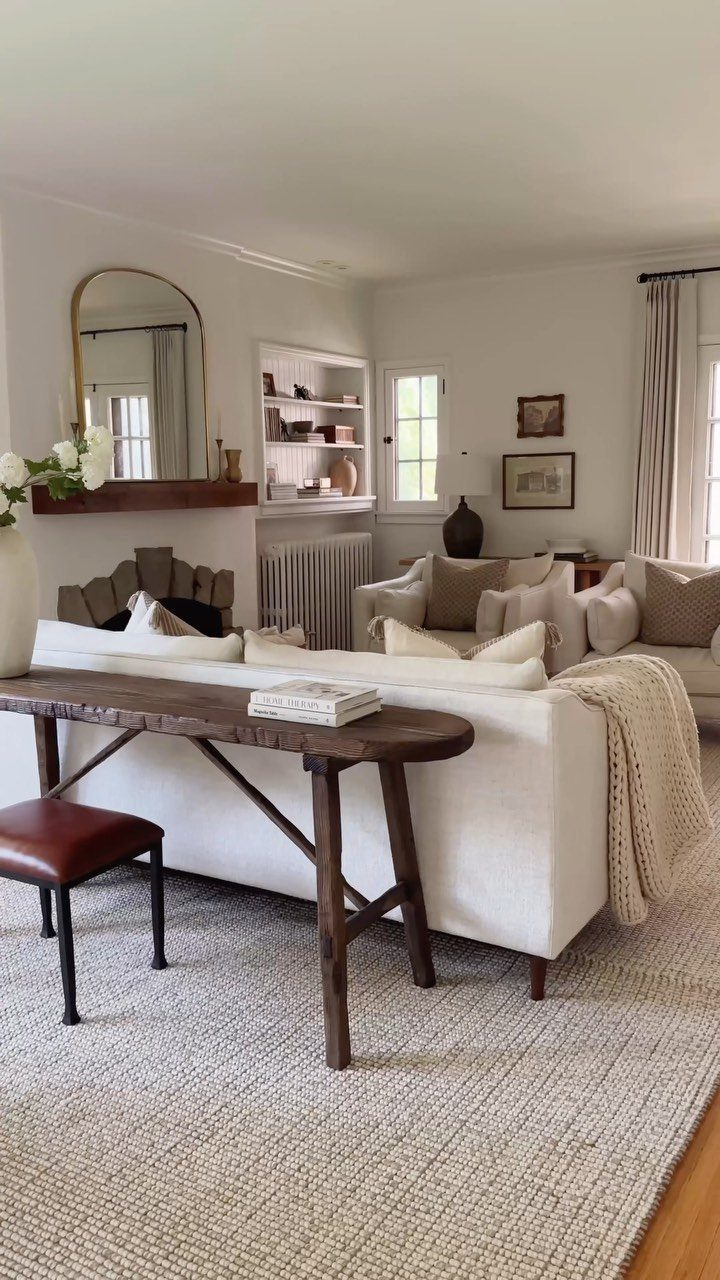 Honey Oak Wood Floors: 8 Design Ideas That Work 1 A large, light-colored textured area rug sits under a white sofa and wooden console table.