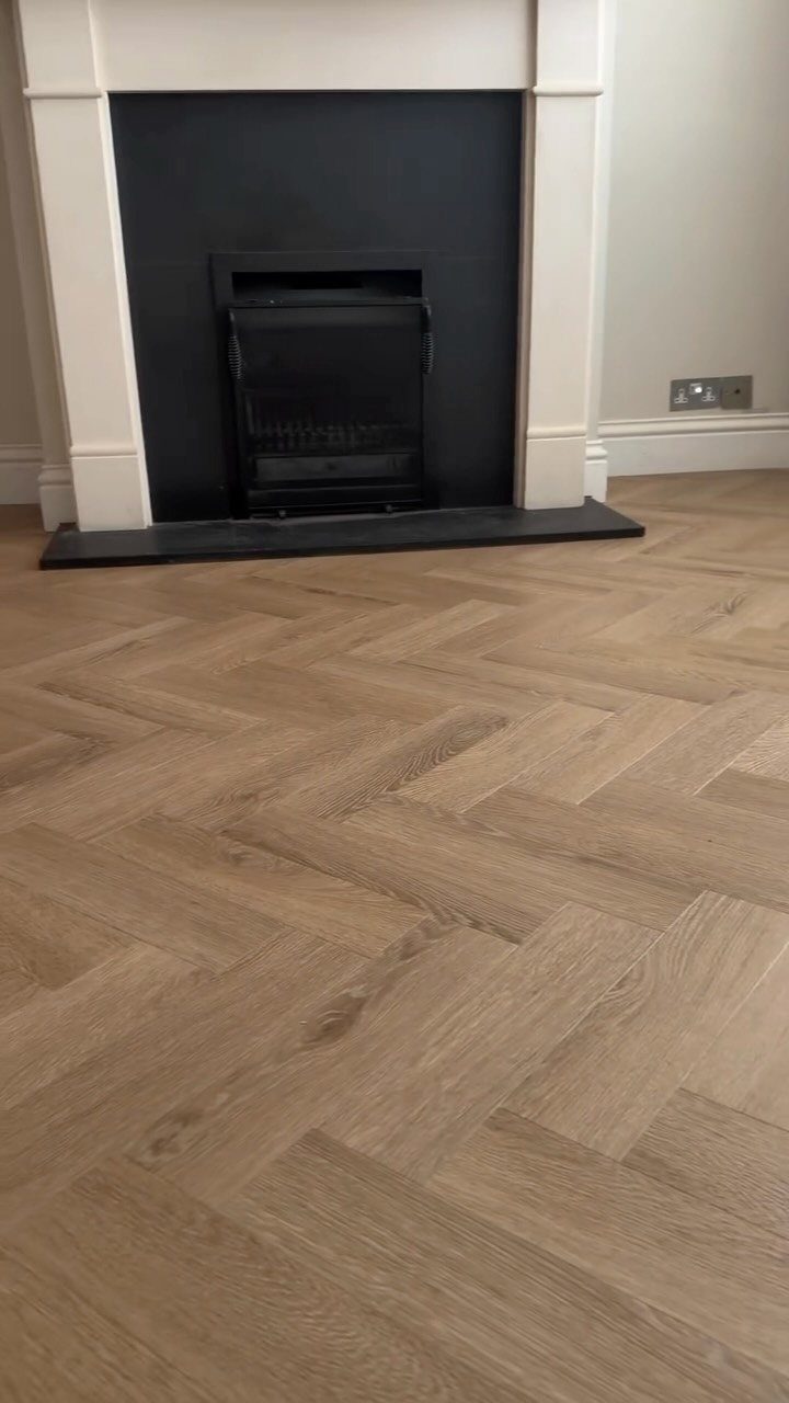 Honey Oak Wood Floors: 8 Design Ideas That Work 2 Herringbone pattern light wood flooring in a room with a white fireplace.