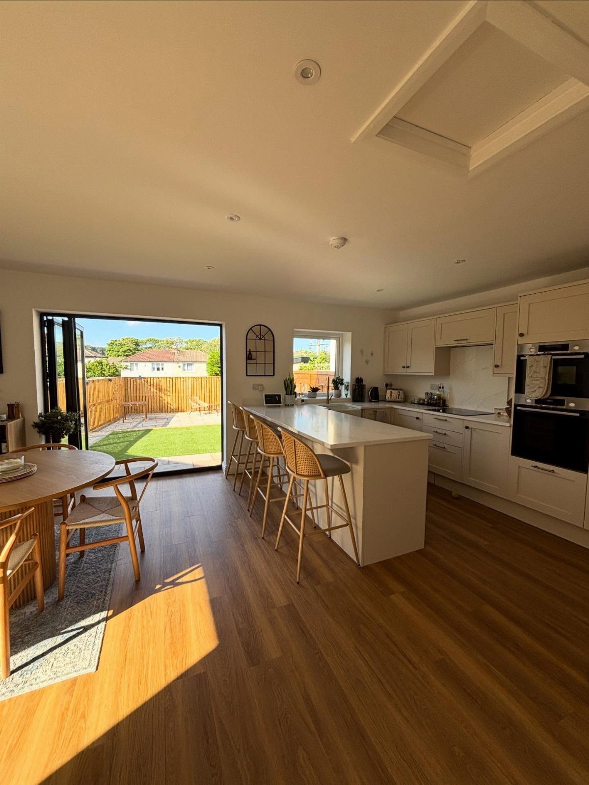 Honey Oak Wood Floors: 8 Design Ideas That Work 5 Light wood flooring in a bright, modern kitchen and dining room with white cabinets.
