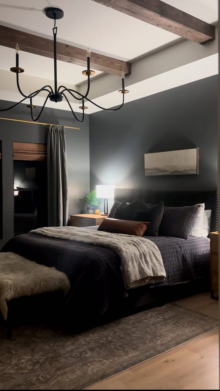 Interior Color Schemes: 9 Real Rooms That Make Them Work 7 A dark gray bedroom with wooden ceiling beams, a large bed, and a black chandelier.