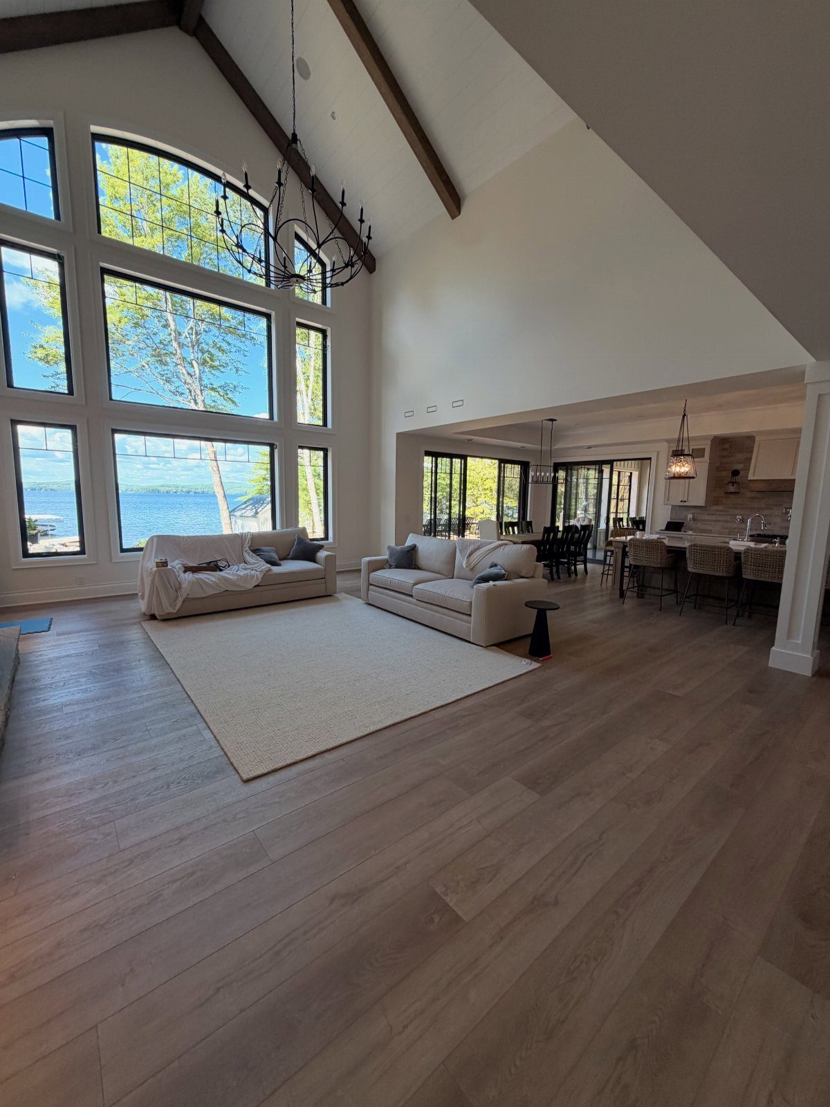Light LVP Flooring: 5 Design Ideas for Bright Rooms 5 Light wood-look flooring in a bright, modern living room with large windows and cream sofas.