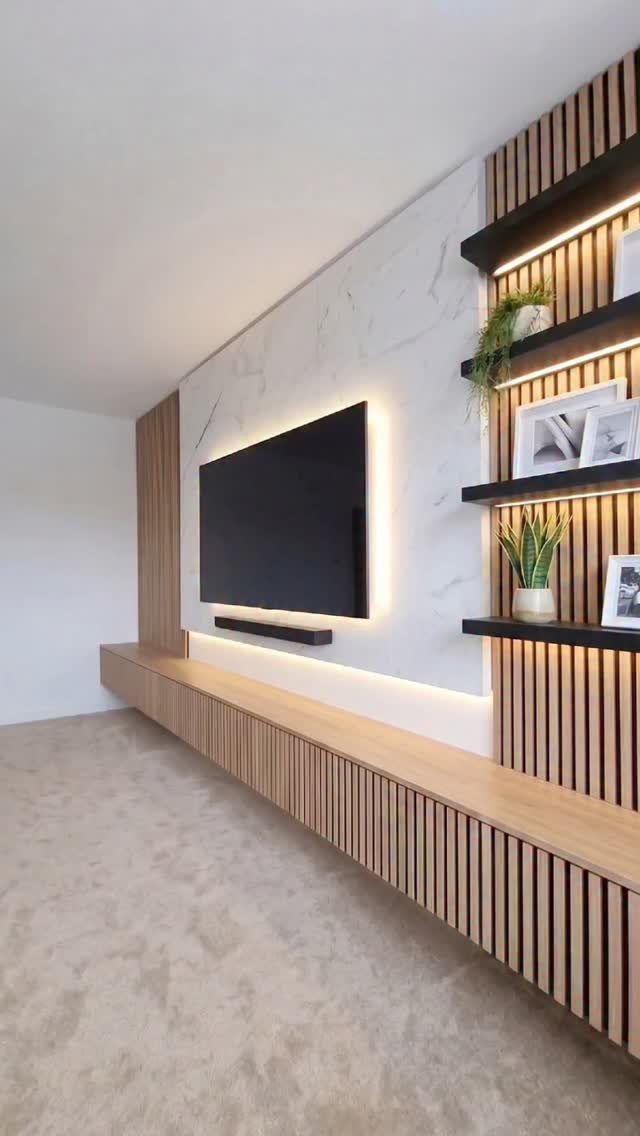 Modern living room wall with marble panel, LED backlighting, and vertical wooden slatting with shelves.