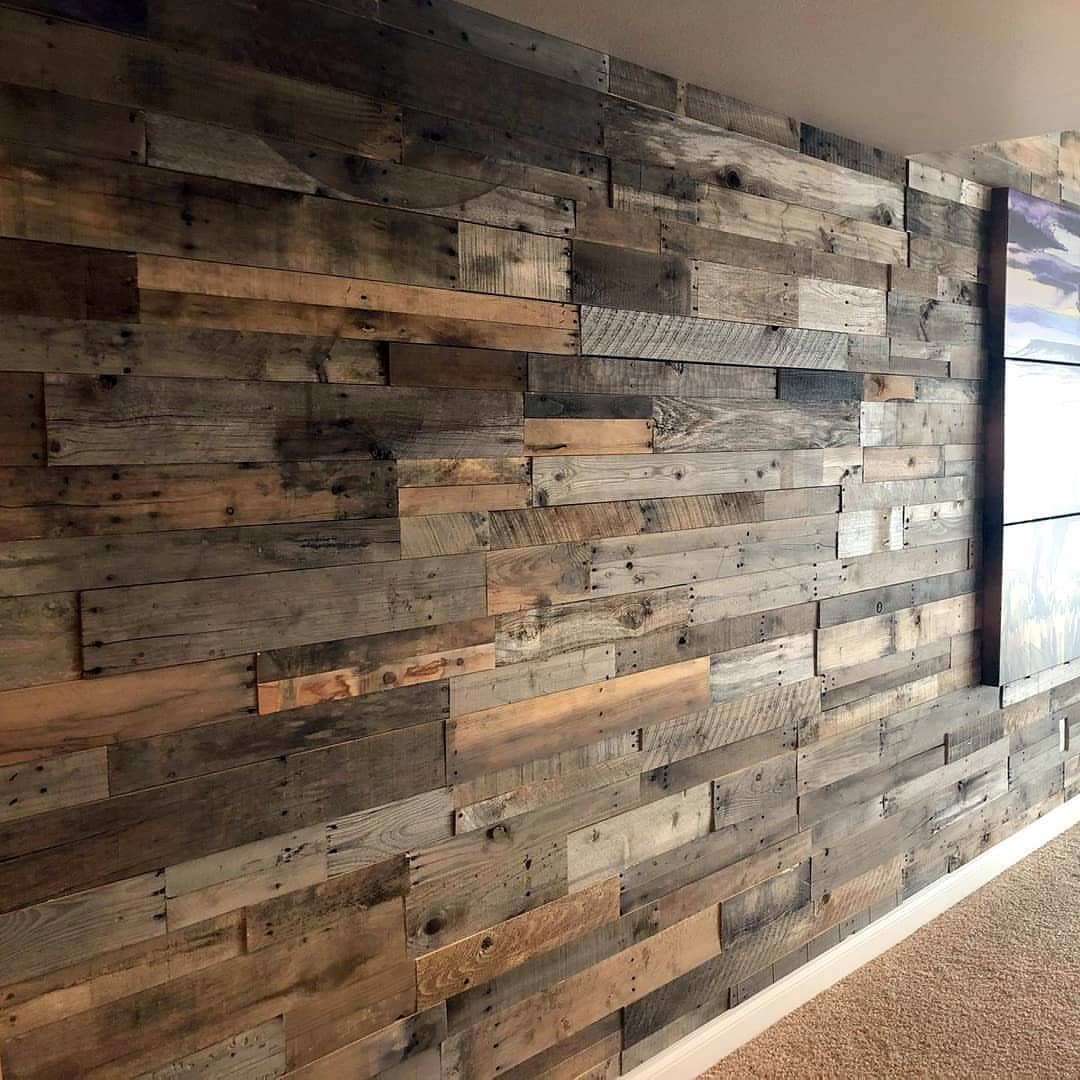 Reclaimed wood planks of varying shades and textures covering a large interior feature wall.