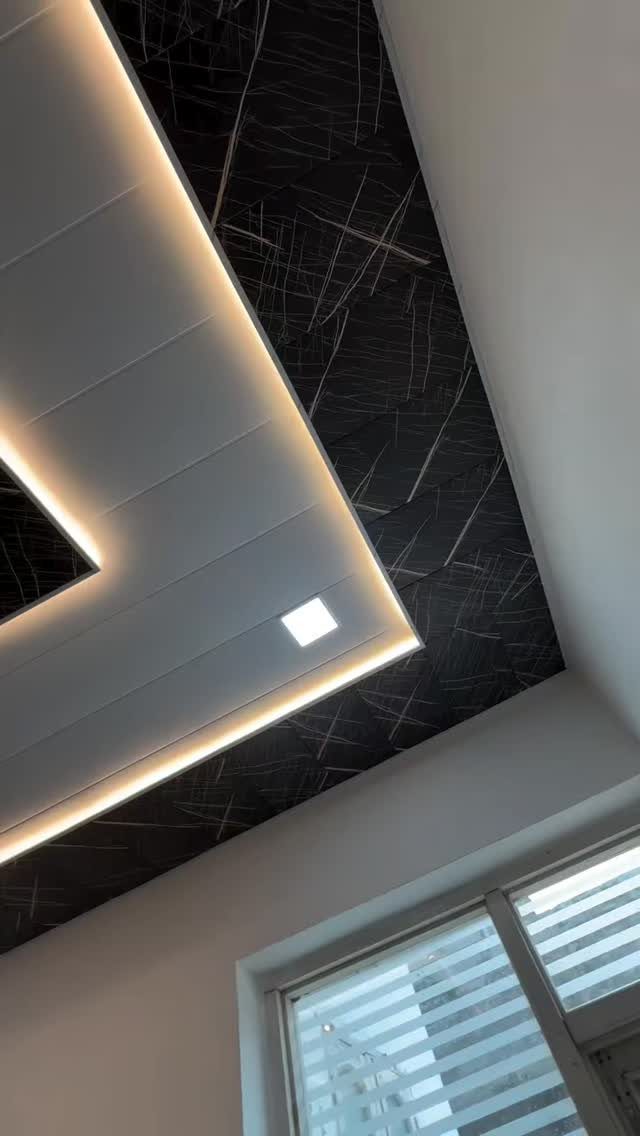 Modern black and white ceiling with recessed white panel and warm cove lighting