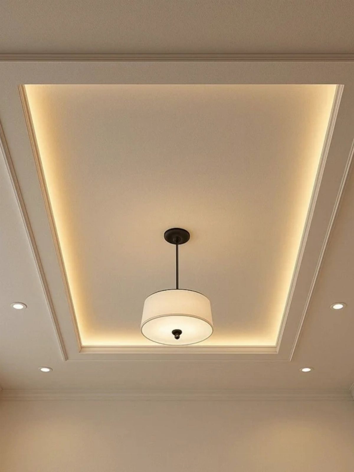 White recessed ceiling with clean framing, warm cove lighting, and a central pendant lamp.