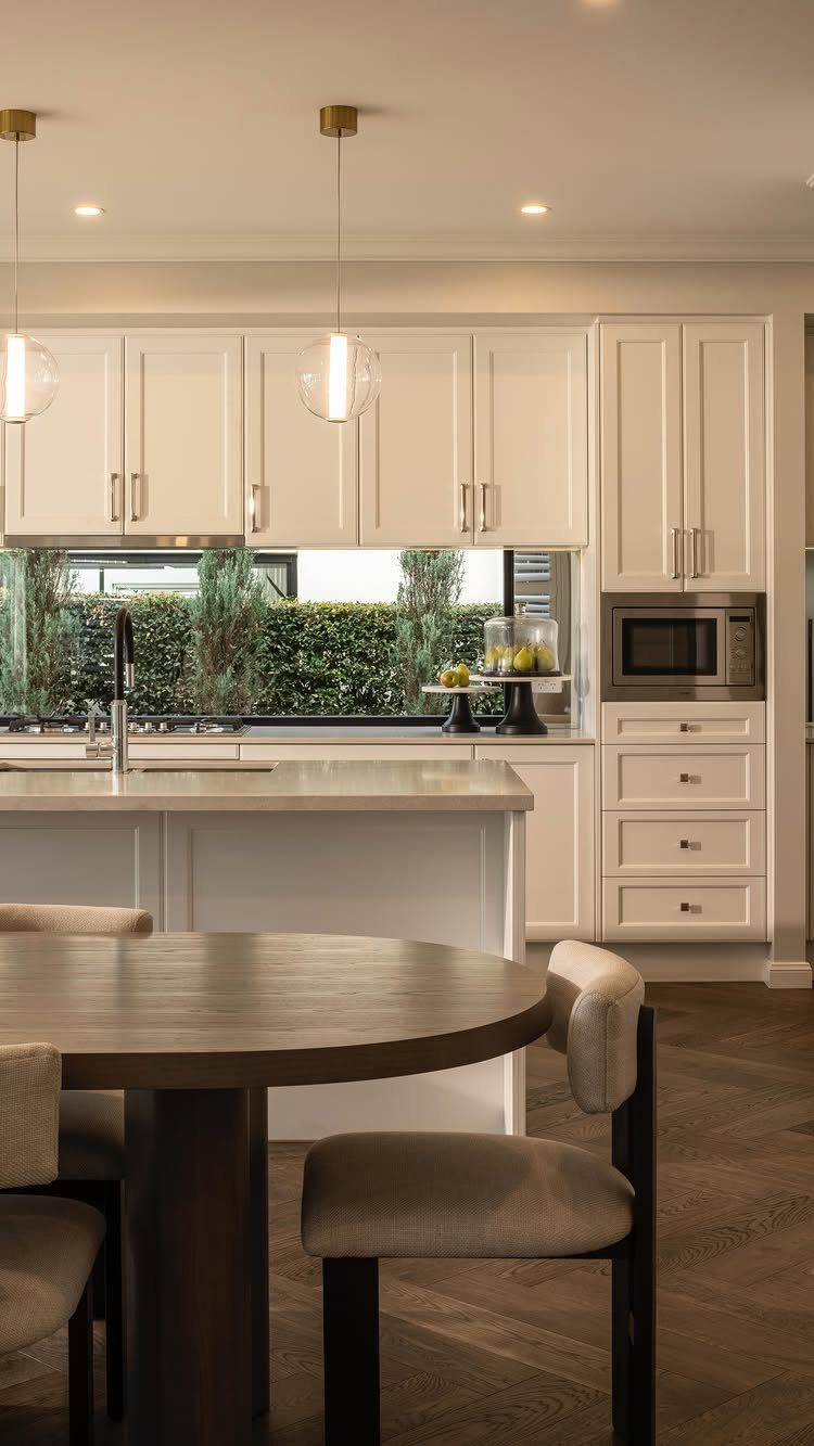 10 Modern Farmhouse Flooring Ideas for Every Room 5 Herringbone pattern dark wood flooring in a modern white kitchen and dining room setting.