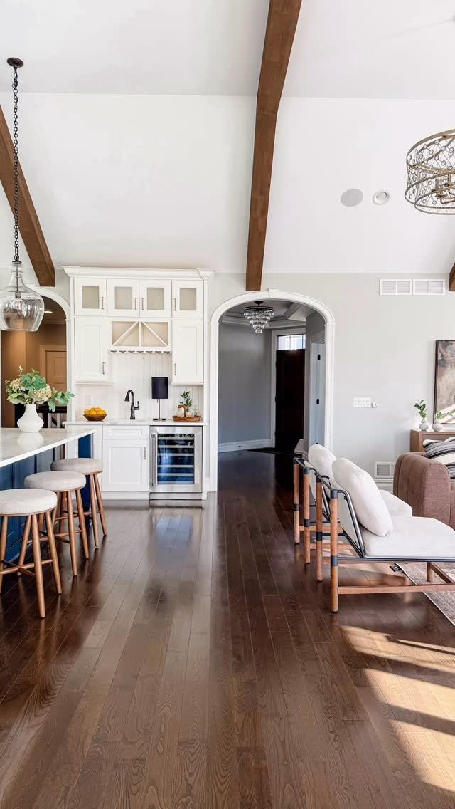 10 Modern Farmhouse Flooring Ideas for Every Room 2 Dark stained hardwood flooring stretching through a bright, modern farmhouse kitchen and living space.