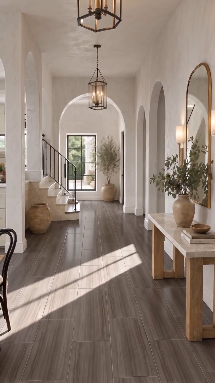 10 Modern Farmhouse Flooring Ideas for Every Room 7 Dark grey wood-look tile flooring in a bright, modern farmhouse hallway with arched entryways.