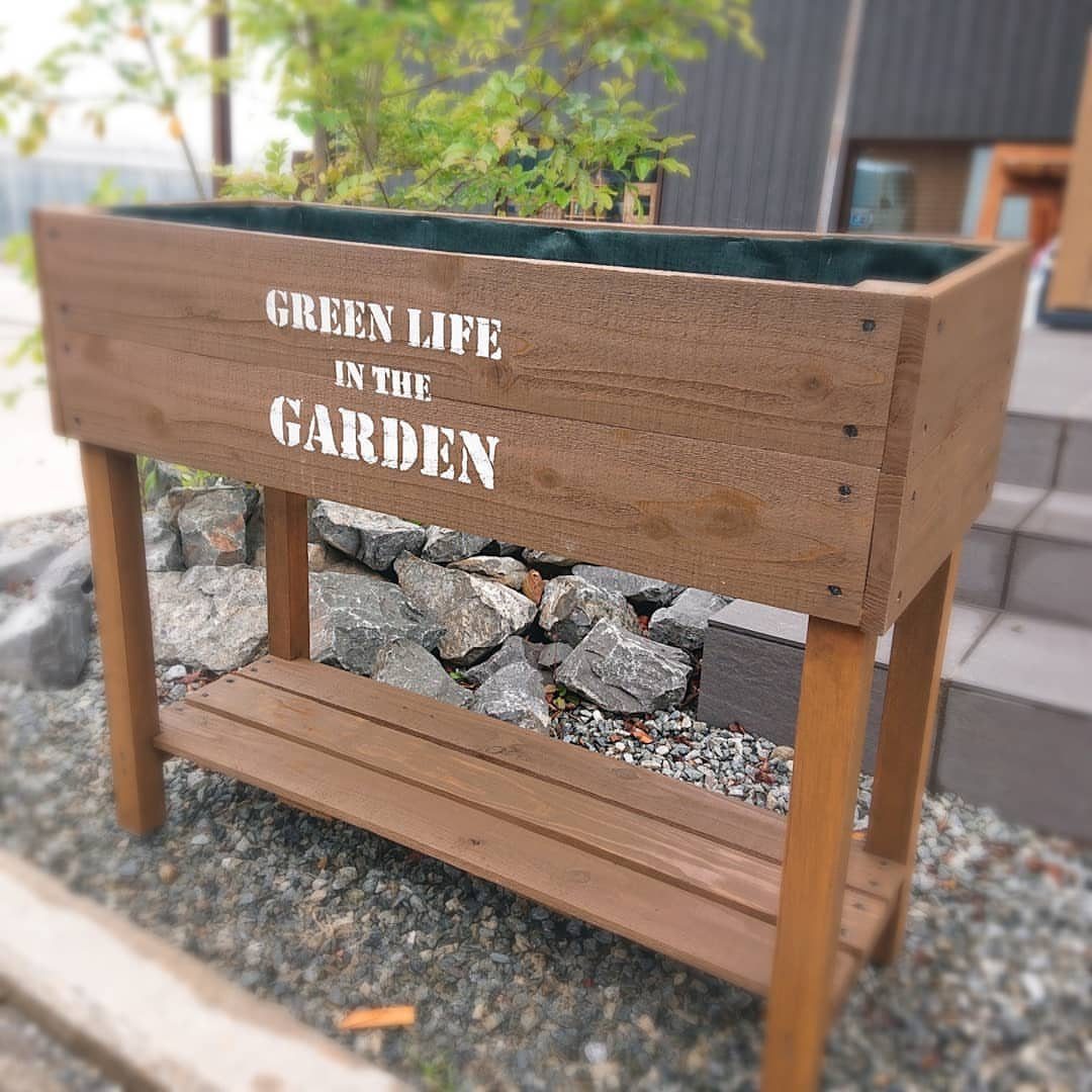 Painted Raised Garden Beds: 11 Ideas for Your Yard 11 Wooden raised garden bed with white lettering on a gravel outdoor surface