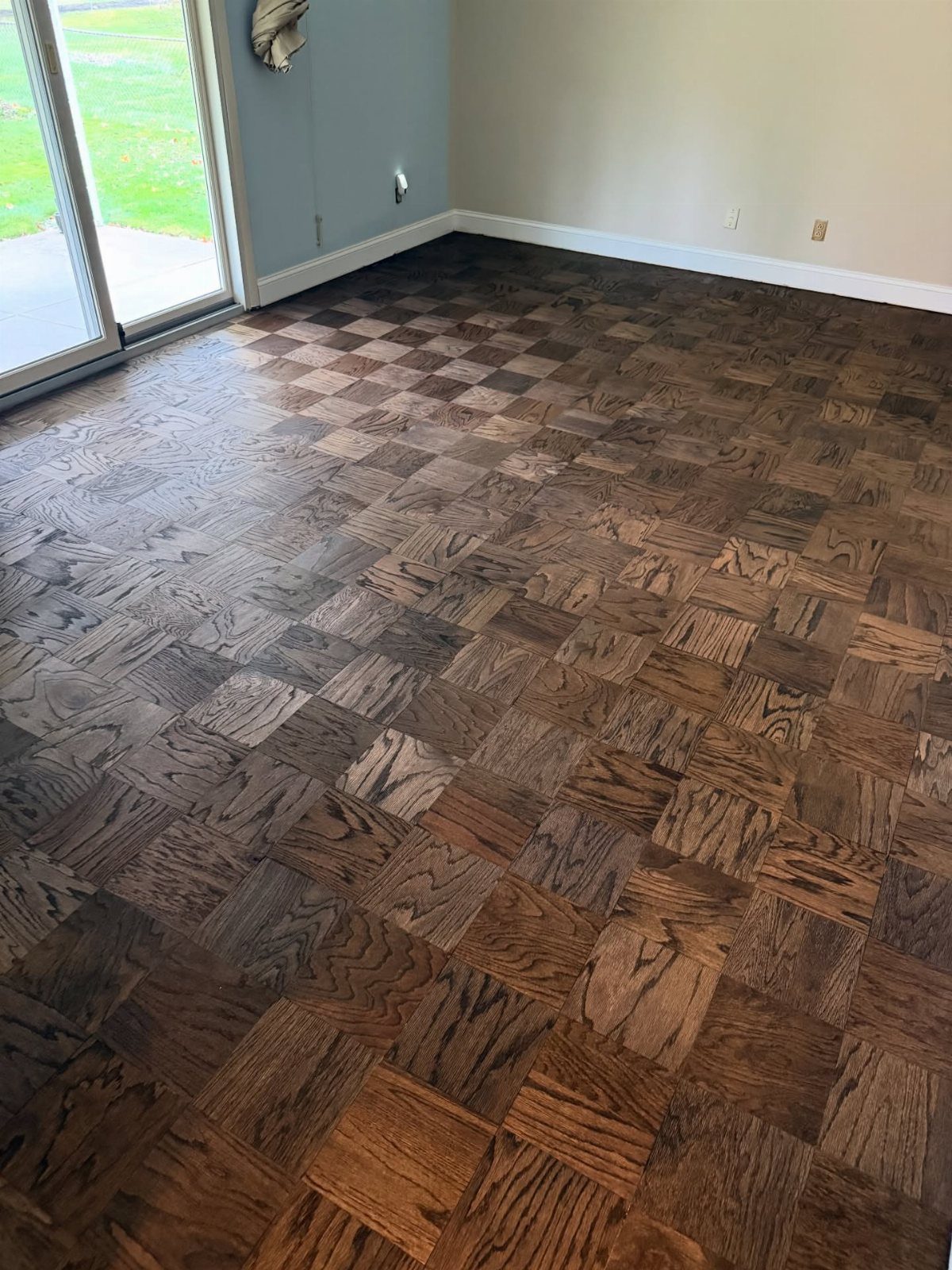 Parquet Floor Pattern: 8 Historic Layouts That Still Define Interiors 5 Dark wood parquet floor with a checkerboard pattern in a room with light walls.