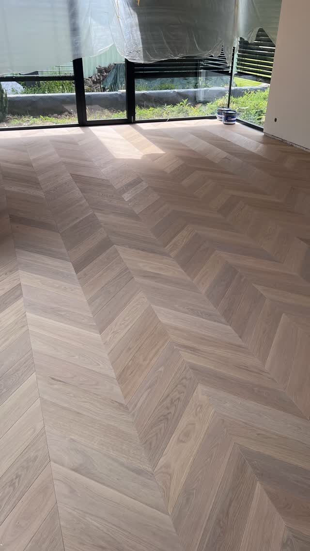 Parquet Floor Pattern: 8 Historic Layouts That Still Define Interiors 1 Light wood parquet floor featuring a seamless chevron pattern in a bright room.