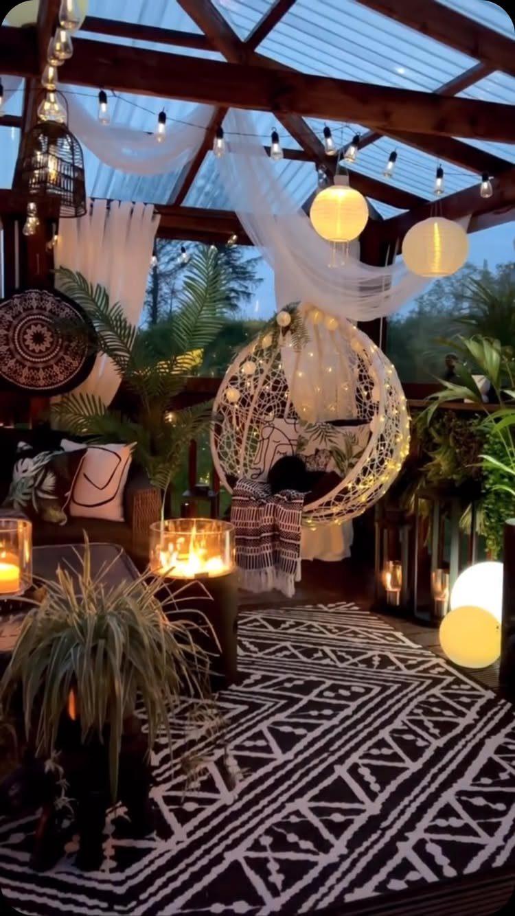 25 Patio Lights Ideas, From String Lights to Step Lighting 2 Wooden pergola with string lights, globe lanterns, and white fabric draping over a cozy seating area.