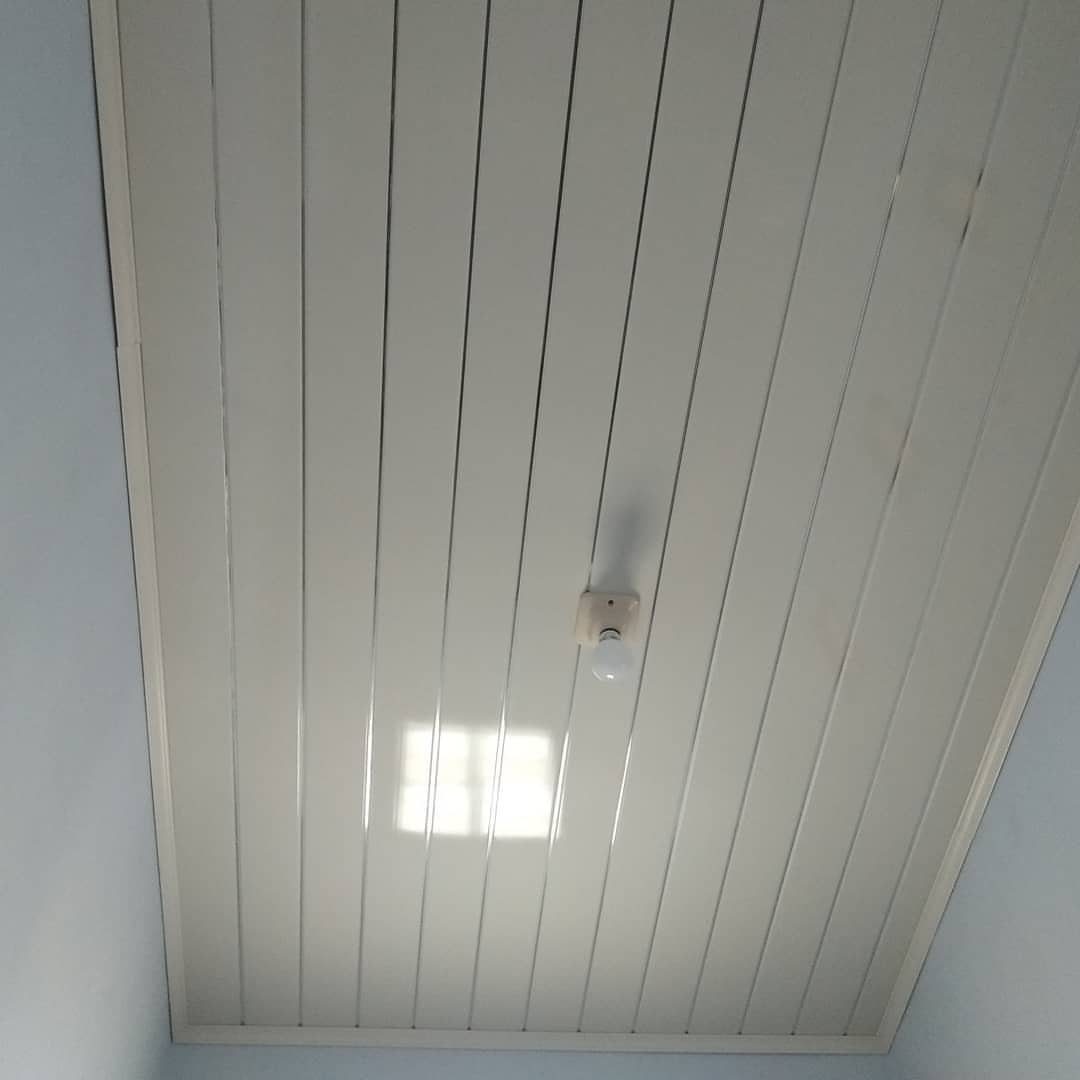 White glossy PVC ceiling panels with a single light bulb fixture in the center.