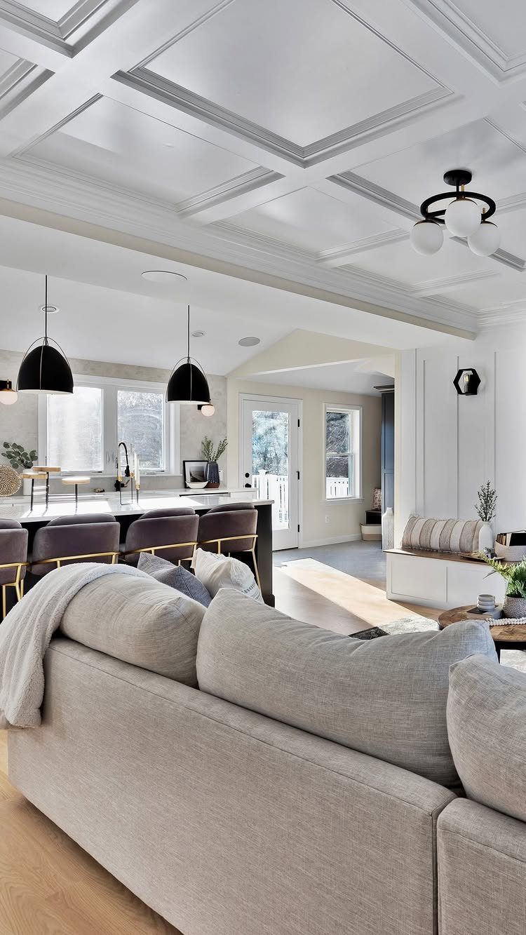 White coffered ceiling with rectangular recesses in a modern, bright living room interior.