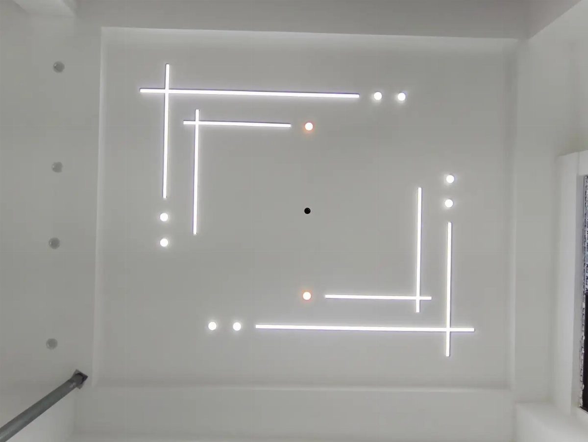 White POP ceiling with intersecting linear light strips and small circular halogen spotlights.
