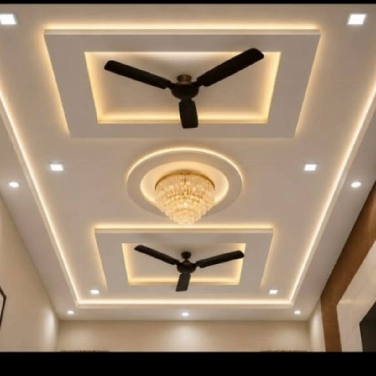 White POP ceiling with recessed rectangular and circular sections, chandelier, and spotlights.