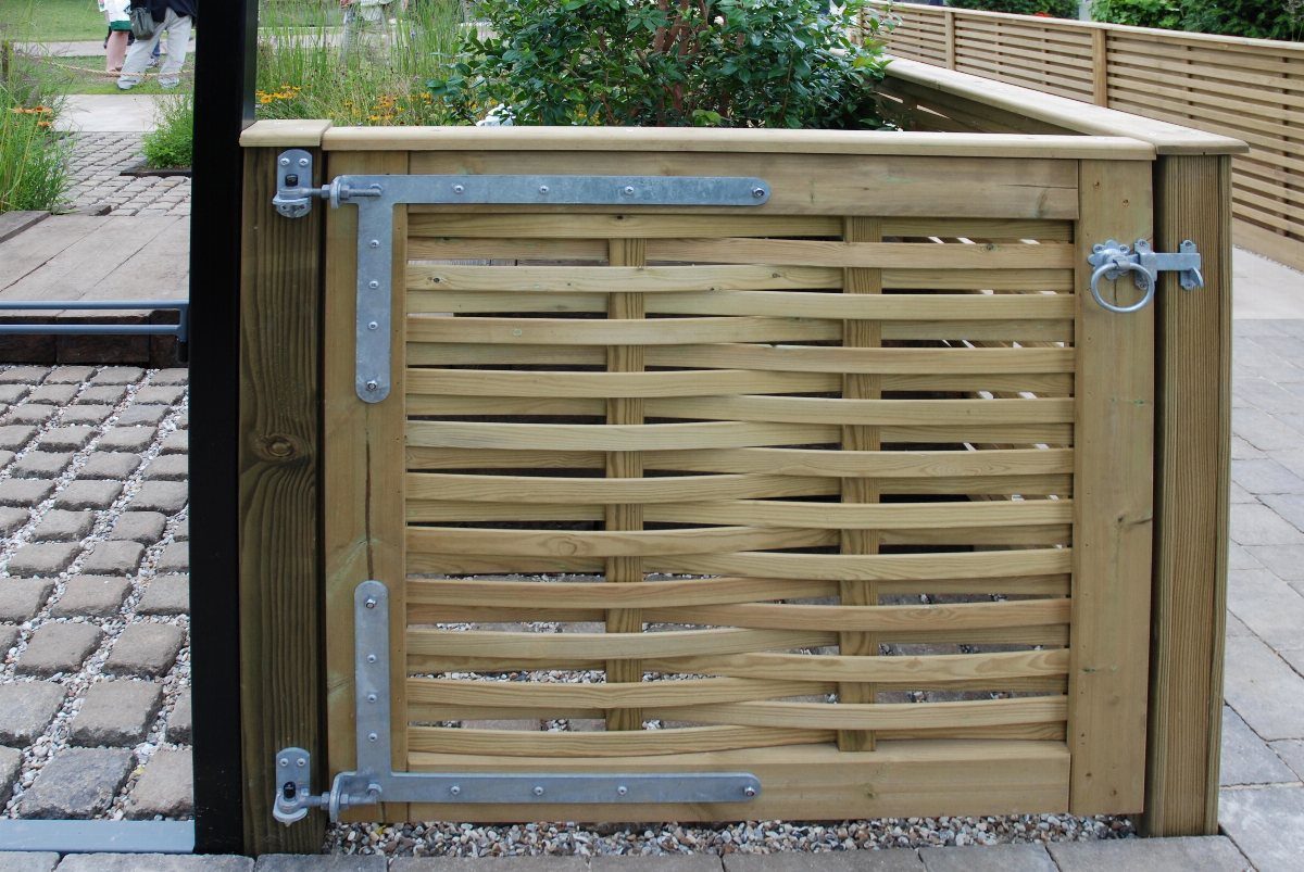 Woven wooden garden gate with silver metal hardware and a stone path.