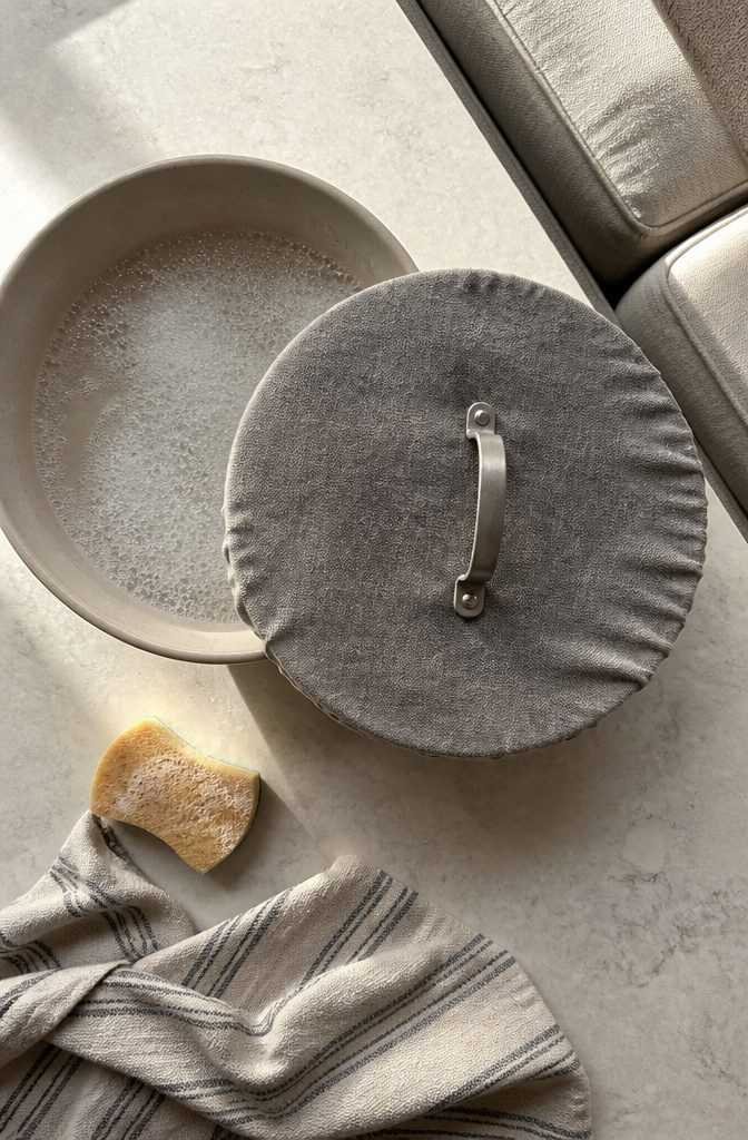 Sofa Cleaning Hack: Using a Fabric-Covered Lid on Upholstery 2 Fabric-covered pot lid submerged in a bowl of cleaning solution