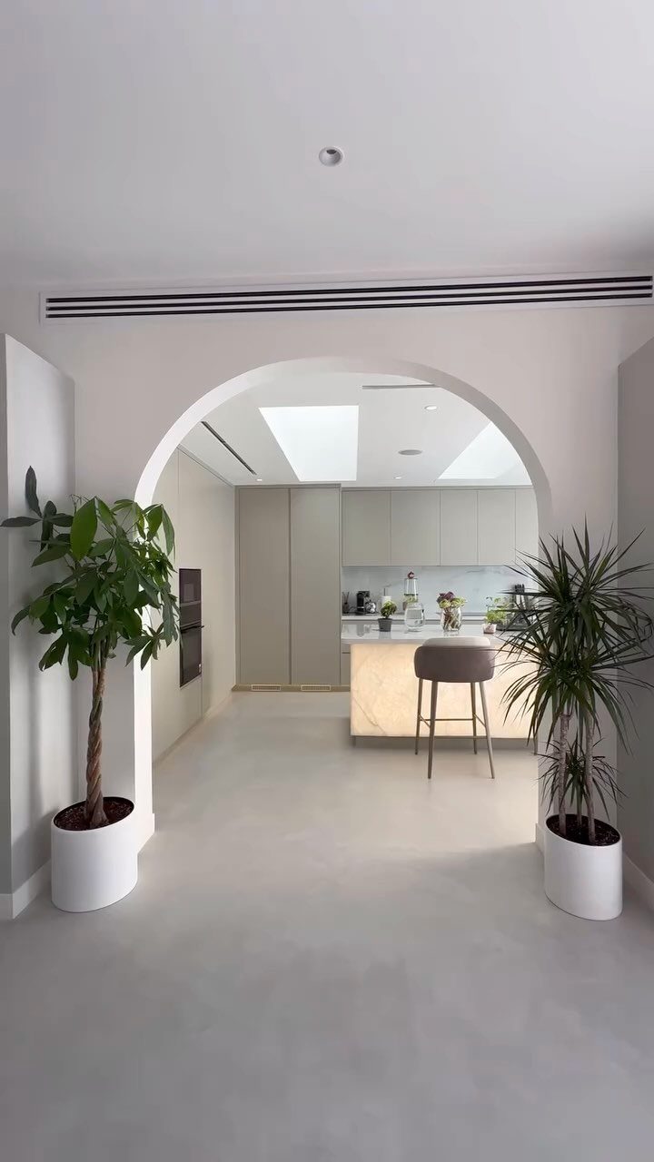 Types of Flooring: 10 Ideas from Hardwood to Rubber 4 Light grey seamless concrete flooring in a modern minimalist kitchen seen through an archway.