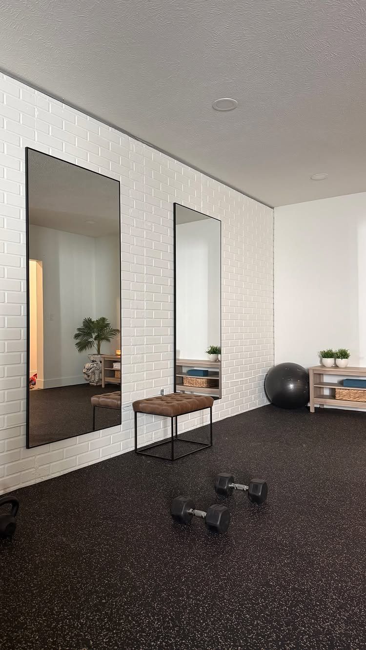 Types of Flooring: 10 Ideas from Hardwood to Rubber 7 Dark speckled rubber flooring in a home gym with mirrors and dumbbells.