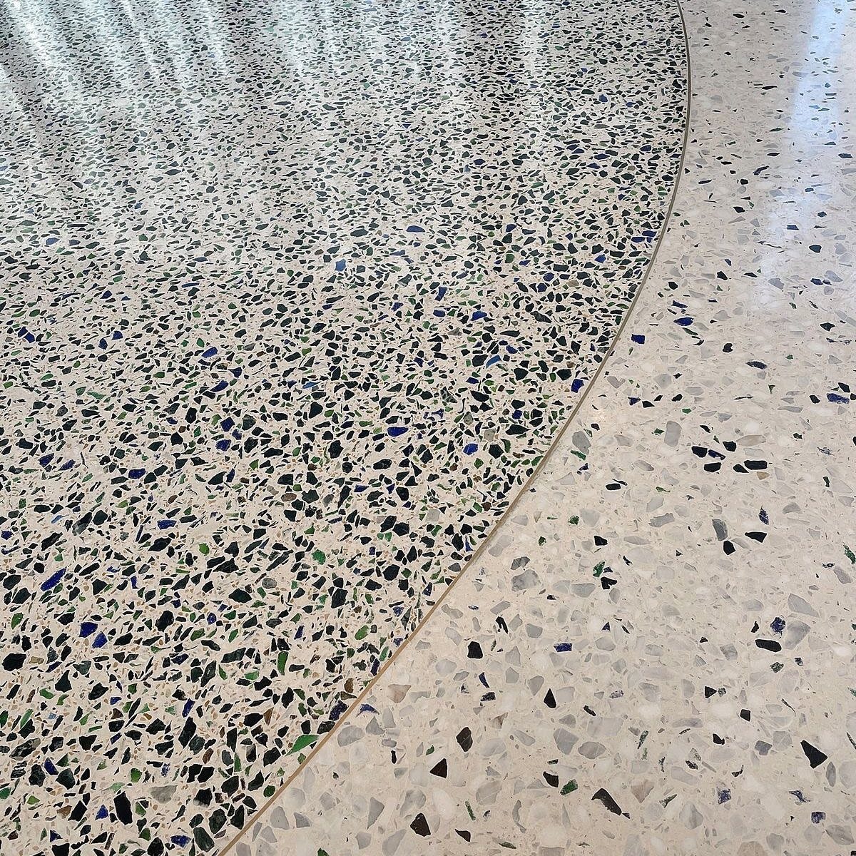 Types of Flooring: 10 Ideas from Hardwood to Rubber 8 Two different patterns of terrazzo stone flooring meeting at a curved dividing line.
