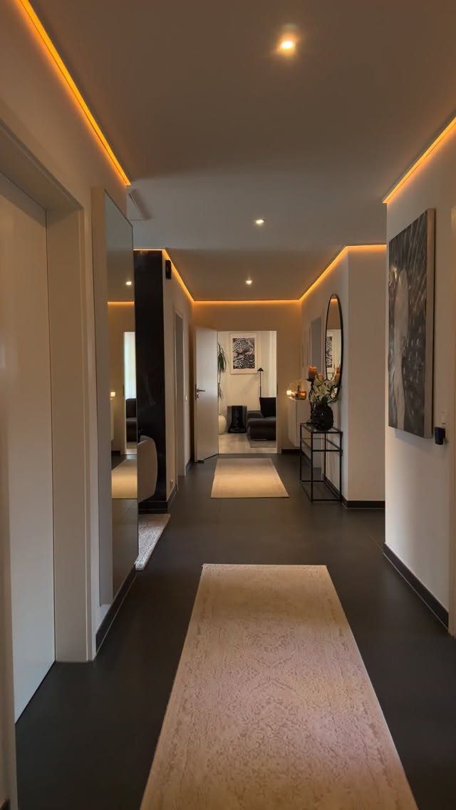 9 Vinyl Floor Colors for Every Room in 2026 7 Dark black hallway floor with two light beige runners and warm ambient lighting.