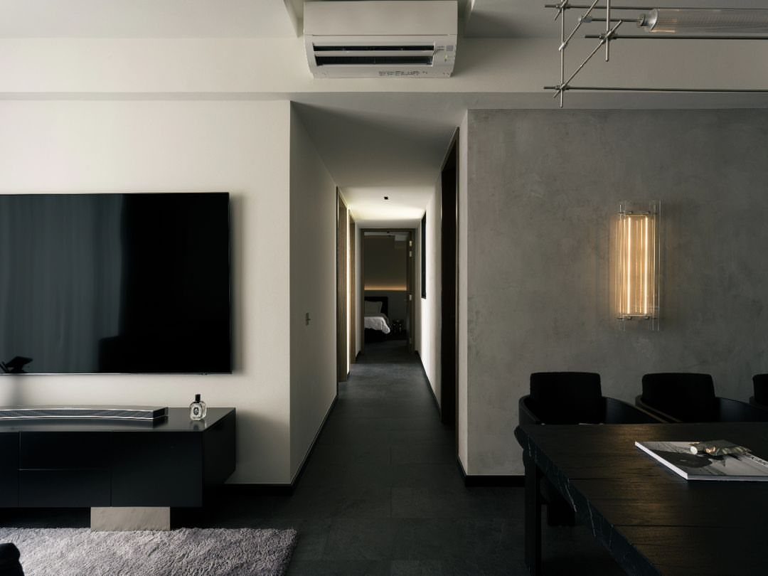 9 Vinyl Floor Colors for Every Room in 2026 5 Dark charcoal flooring running through a modern living area and into a long hallway.