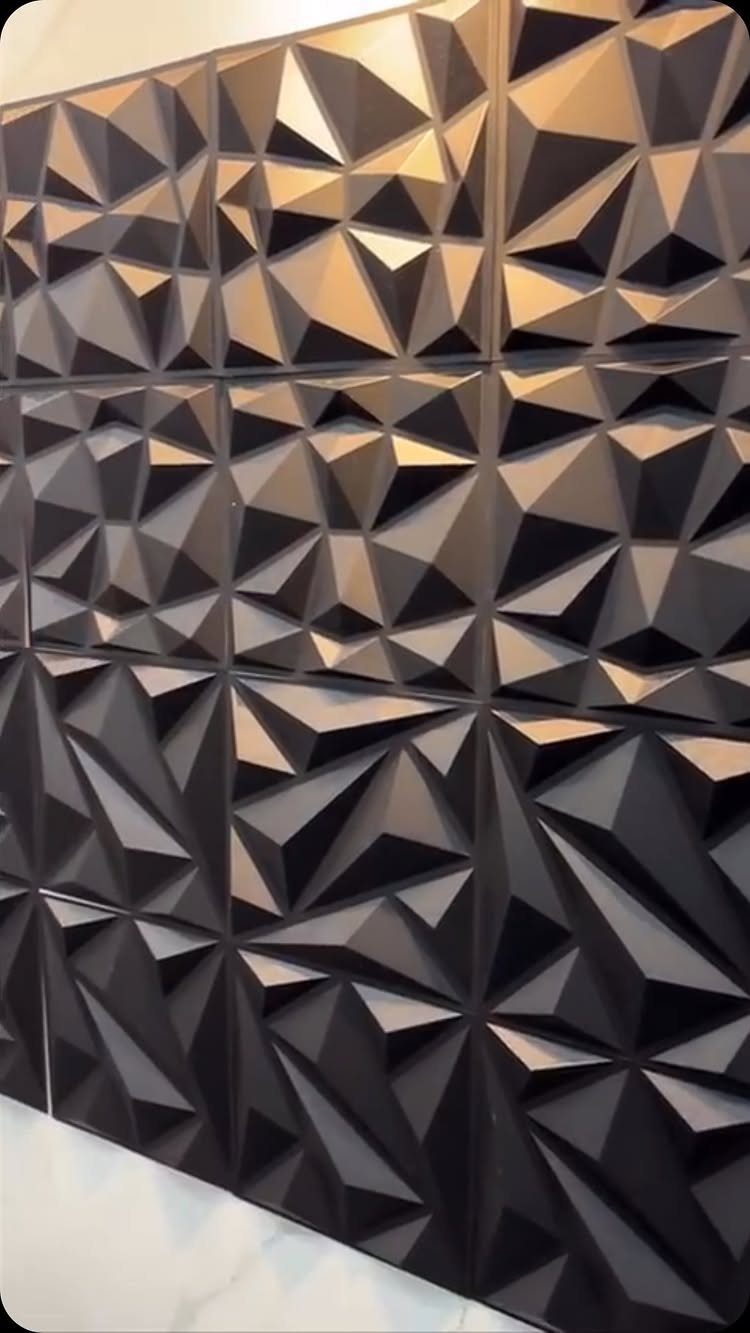 9 Wall Paneling Accent Wall Ideas for Every Room 7 Geometric 3D wall panels with dark, faceted triangular shapes creating a textured accent wall.