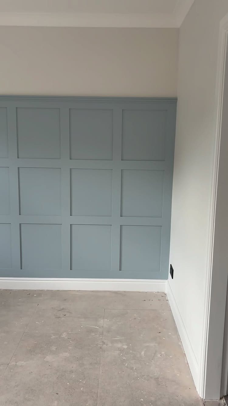 9 Wall Paneling Accent Wall Ideas for Every Room 2 Light blue wall with square panel moulding in a grid pattern against white baseboards.
