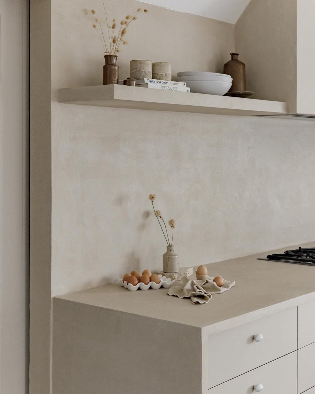 Wall Texture Design: 12 Ideas for Every Room 11 Beige concrete texture wall in a minimalist kitchen with a floating shelf and countertop.