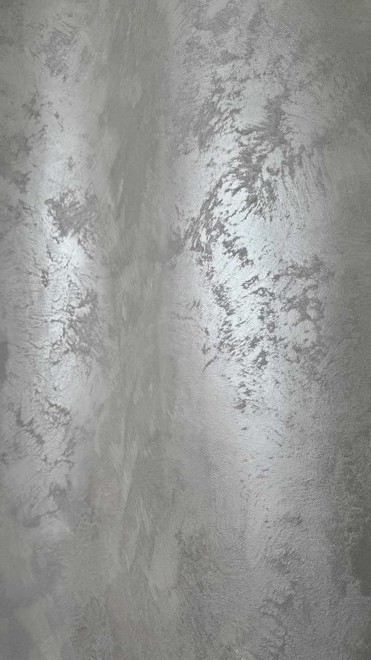 Wall Texture Design: 12 Ideas for Every Room 1 Silver metallic textured paint applied to a wall with shimmering, mottled patterns.
