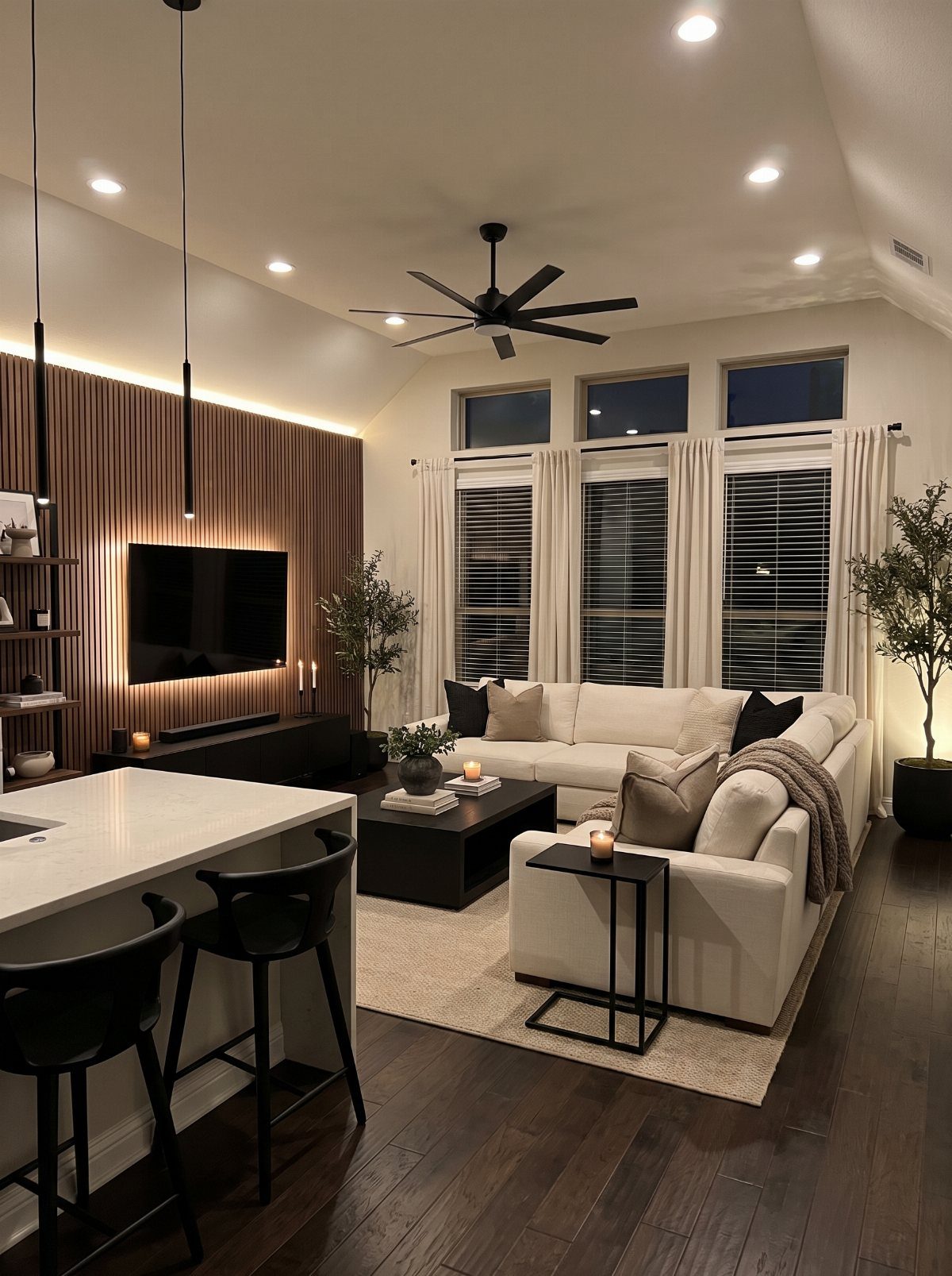 Modern living room with white furniture and contrasting dark brown hardwood floors.