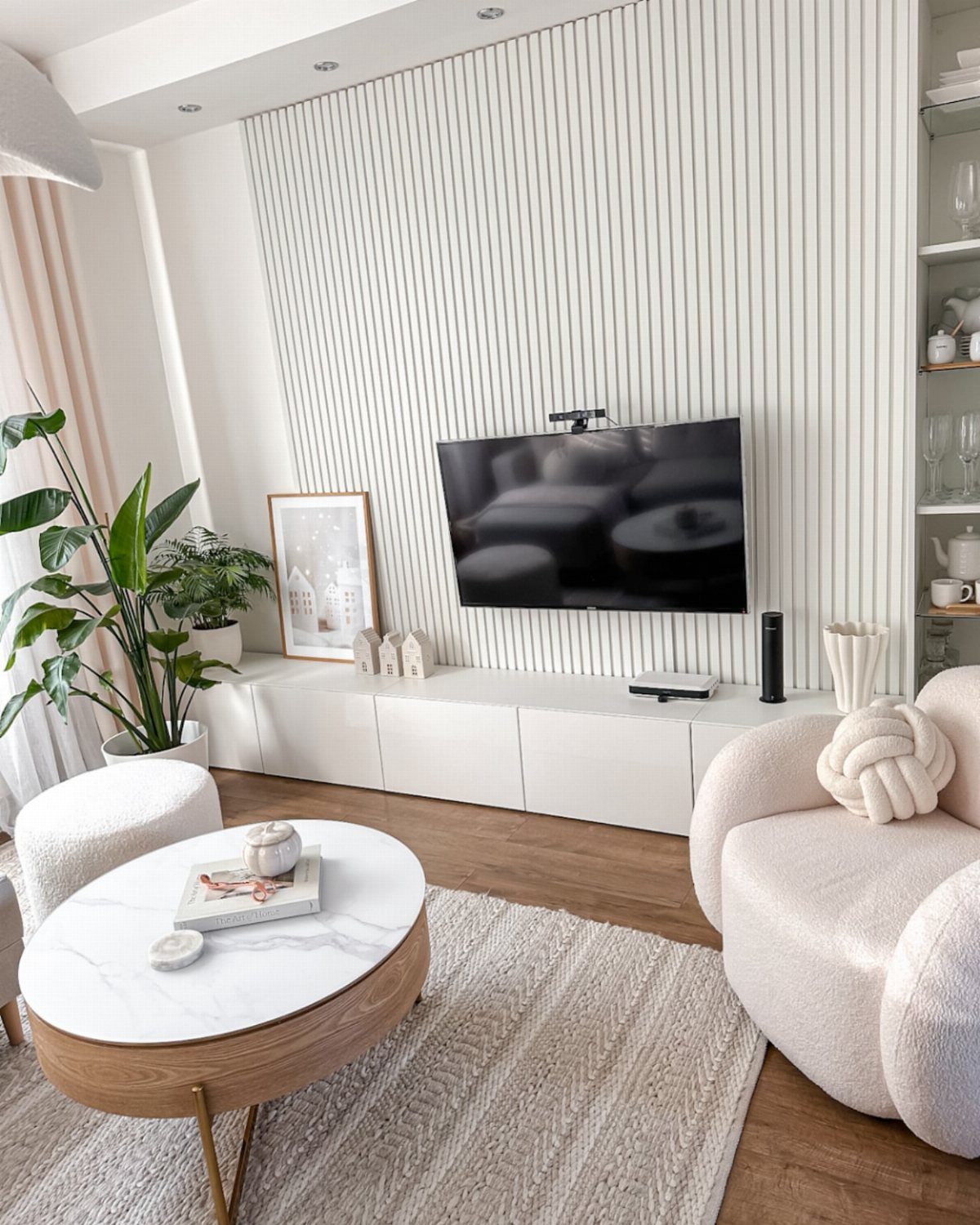 White slatted wall panels behind a television in a modern minimalist living room.