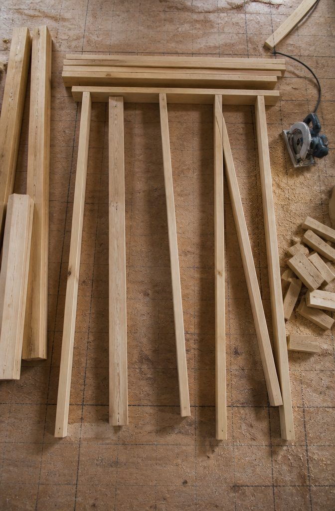 Wood Framing Wall: From Lumber Selection to Interior Finish 2 Cut studs and plates displayed on a workbench, ready for wall assembly.